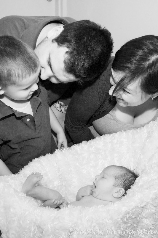 Family smiling while newborn baby yawns - newborn portrait photography sydney